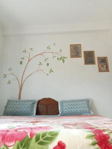 a bedroom with a bed with a tree on the wall at Cocoon Auberge in Jaipur