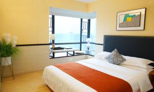 1 dormitorio con cama grande y ventana grande en Guangzhou Timmy Hotel, en Guangzhou