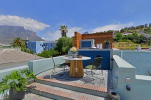 a patio with a table and chairs on a roof at Bo-Kaap Elegance Historic Luxury & Mountain Views in Cape Town