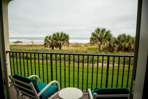 a balcony with two chairs and a view of the beach at Ocean Landings Resort in Cocoa Beach