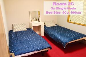 1 dormitorio con 2 camas y espejo en Furano House, JR Station, 2F Apartment, 3 Bedrooms, Max 8PP - 6 Adults 2 Kid, Onsite Parking en Furano