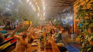 a group of people sitting at a table with their hands in the air at SECRET GARDEN CAT BA in Cat Ba