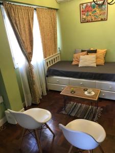Un dormitorio con una cama y dos sillas y una mesa. en Confortable. Excelente ubicación., en La Plata