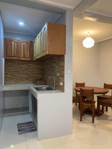 eine Küche und ein Esszimmer mit einem Waschbecken und einem Tisch in der Unterkunft Lakayo Hillside Apartelle in san juan la union