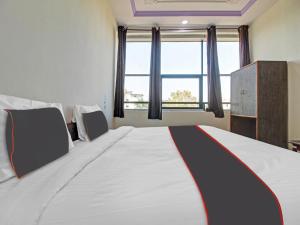 a bedroom with a large bed with a large window at Super Collection O Fortune Inn in Pune