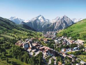 uma vista aérea de uma cidade num vale com montanhas em Studio pied des pistes 4 personnes em Les Deux Alpes