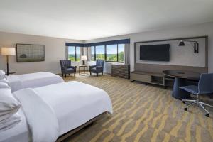 a hotel room with two beds and a flat screen tv at Portland Sheraton at Sable Oaks in South Portland
