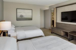 a hotel room with two beds and a flat screen tv at Portland Sheraton at Sable Oaks in South Portland