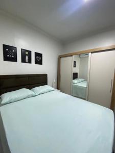 a bedroom with a white bed and a large mirror at Apto refúgio 101 em São Luís/MA (inteiro) in São Luís