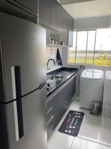 a kitchen with a refrigerator and a sink and a sink at Apto refúgio 101 em São Luís/MA (inteiro) in São Luís