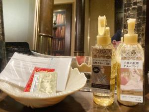 two bottles of soap and a bowl on a table at Restay Tina Grace (Adult Only) in Hadano
