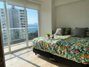 a bedroom with a bed and a large window at LECLUB ACAPULCO in Acapulco