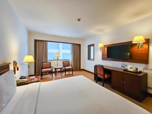 Pokój hotelowy z łóżkiem i biurkiem w obiekcie Ramada by Wyndham D MA Bangkok w mieście Bangkok