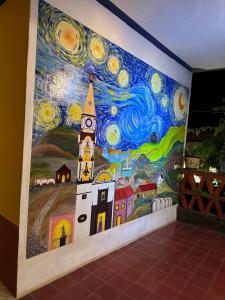 un mur orné d'une fresque murale représentant un bâtiment et une tour d'horloge dans l'établissement Copa de Oro Hotel Boutique, à Mascota