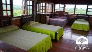 Habitación con 3 camas en una habitación con ventanas en Finca Hotel El Bonsai, en Montenegro
