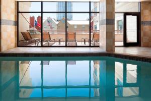 a swimming pool in a building with chairs and windows at Residence Inn Austin Downtown / Convention Center in Austin