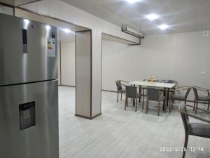 a room with a refrigerator and a table with chairs at Ikat Terrace in Bukhara