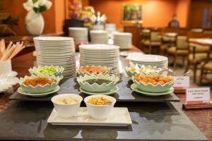 een buffet met borden en kommen eten op een tafel bij Ramada by Wyndham D MA Bangkok in Bangkok