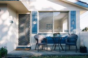 a patio with a table and chairs on a porch at Torquay Retreats Aus- TwentyTwo Pride in Torquay