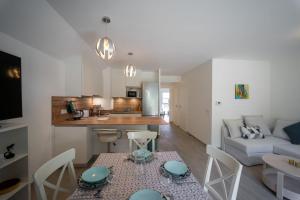 sala de estar y cocina con mesa y sillas en Au bonheur du lac charmant appartement pour 4 personnes en Duingt