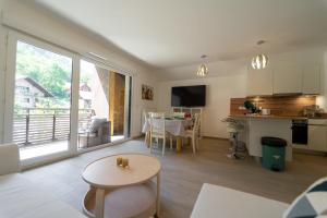 sala de estar con mesa y cocina con vistas. en Au bonheur du lac charmant appartement pour 4 personnes, en Duingt 5 fotos más