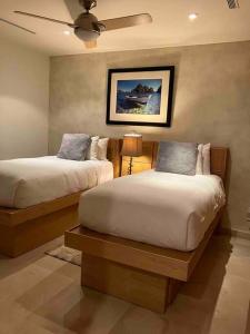 1 dormitorio con 2 camas y ventilador de techo en 2BD & 2BA One Medano Beach Kathys Home, en Cabo San Lucas