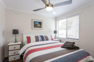 a white bedroom with a bed and a window at Torquay Retreats Aus- TwentyTwo Pride in Torquay