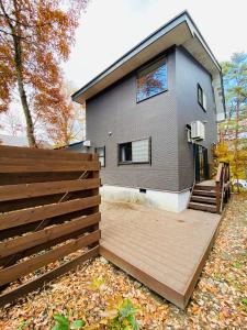 a house with a wooden deck in front of it at Bond Chalet Hakuba - Vacation STAY 76698v in Hakuba