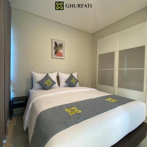 a bedroom with a large bed with yellow symbols on it at Ghurfati Hotel Wedana in Jakarta