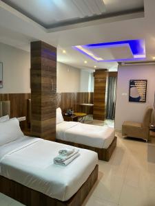 a hotel room with two beds and a couch at Hotel Avenue Suites Near International Airport Bangalore in Bangalore +86 photos