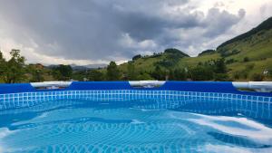 a blue swimming pool with mountains in the background at Poarta Craiului in Şirnea