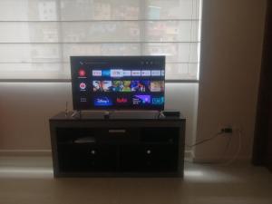 a flat screen tv sitting on a black entertainment center at LINDA SUITE Puerto Santa Ana GUAYAQUIL in Guayaquil