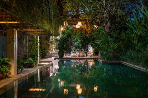 a swimming pool in a house with trees and plants at The Kemilau Hotel & Villa Canggu Bali in Canggu