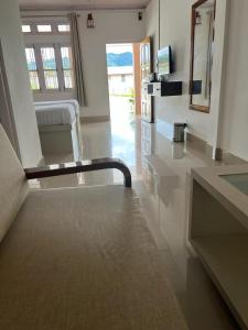 a white room with a couch and a mirror at Hotel Anne Ziro in Hāpoli