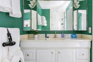 a bathroom with a white sink and green walls at Beautiful & Large Townhouse in Downtown Arlington Near DC in Arlington