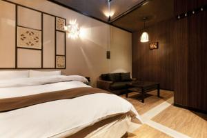 a bedroom with a bed and a chair and a desk at HOTEL GEN 福知山店 in Kumohara