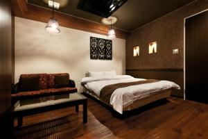 - une chambre avec un lit et une chaise dans l'établissement HOTEL GEN 福知山店, à Kumohara