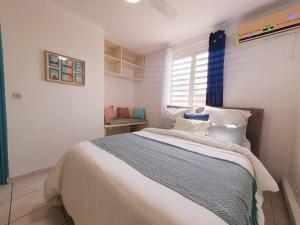 - une chambre avec un grand lit et une fenêtre dans l'établissement Akwatik Appart 150m de la plage, à Les Trois-Îlets