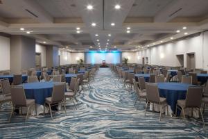 una habitación con mesas y sillas azules y un escenario en Sheraton Oceanfront Hotel, en Virginia Beach