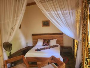 a bedroom with a bed with white sheets and curtains at Haradali's Home in Arusha +165 photos