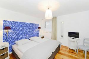 um quarto com uma cama e uma parede azul em Apartments, Wyk auf Foehr em Wyk auf Föhr