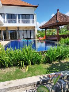 una piscina frente a una casa con cenador en Limun guesthouse, en Ujung