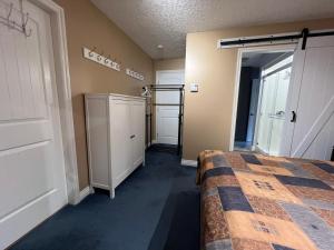 a bedroom with a bed and a closet at Little Bear Garden View Suites-Hummingbird in Royston