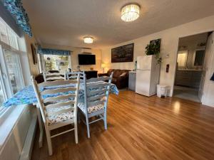 Royston的住宿－Little Bear Garden View Suites-Hummingbird，厨房以及带桌椅的起居室。