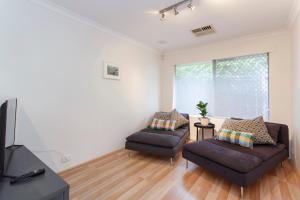sala de estar con 2 sofás y TV en Suburban Villa, en Perth
