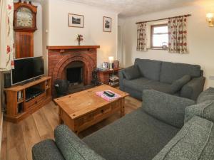 a living room with two couches and a fireplace at Porth Awyr in Llangwnadl