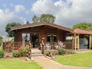 a log cabin with a porch and a gazebo at Cornfield Lodge in Northallerton
