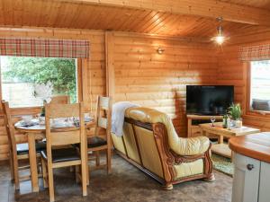 a dining room with a table and a television at Cornfield Lodge in Northallerton