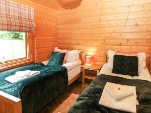 Habitación con 2 camas en una cabaña de madera en Cornfield Lodge, en Northallerton