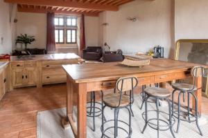 TraizeChâteau beyrin的厨房配有木桌和酒吧凳